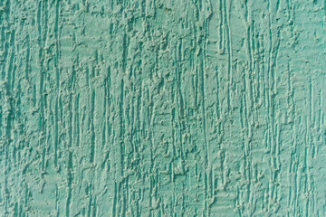 Textured green wall surface with visible cracks and grooves, ideal for use in backgrounds, architectural designs, or construction-themed projects.

