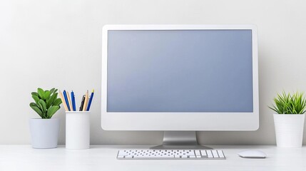 Fototapeta premium Workspace with a computer, keyboard, and plants on a white background.