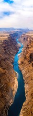 Stunning view of a winding river through a desert canyon under a bright sky.