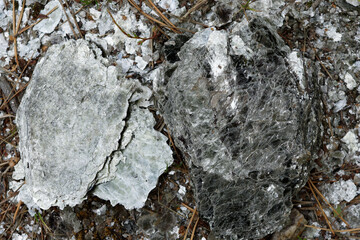 Macro photography of unprocessed pieces of mica minerals in a natural deposit.