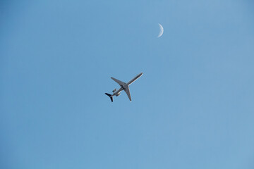 airplane in the sky. moon in background