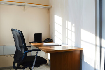 Wooden desk and chair, light interior.