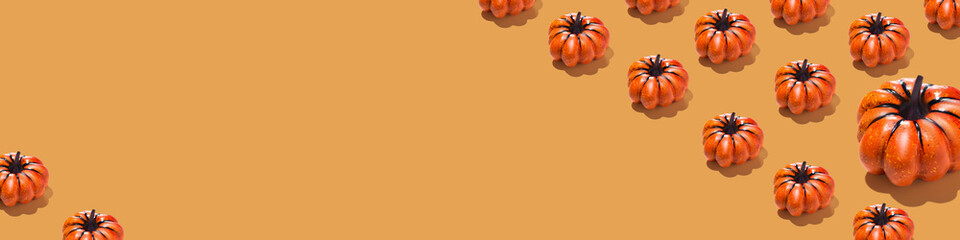 Long Horizontal banner with orange pumpkins pattern on orange background. Minimal Halloween concept copy space