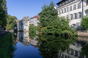Obraz premium Strasbourg, France - August 28th 2024 : View of the Tanner's Quarter with half-timbered buildings and the Ill river and reflections on the water.