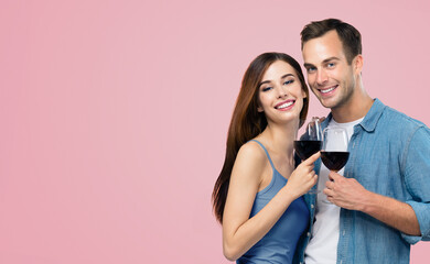 Portrait image - young beautiful cute couple, man and woman holding red wine glasses - love,...