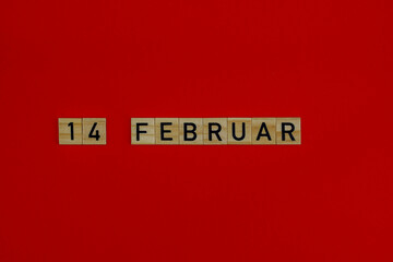 14 februar in wooden blocks on a red background. German language. Valentine's day concept