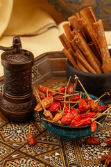 Arabic composition with mill grinder, bowl of spice, peppers, cinnamon, star anise. Shallow depth of field