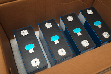 Row of LiFePo4 cells in cardboard box. Prismatic modules for lithium iron phosphate battery....