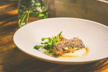 Threadfin with yucca mash, fermented tomato fish jus, laksa oil, pickled fava beans, ikura, capers