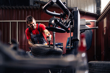 Tire technician mounting winter tires on the wheel. Preparing vehicle for winter season.