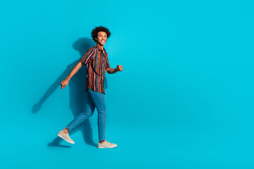 Full size photo of nice young man walk empty space wear shirt isolated on teal color background