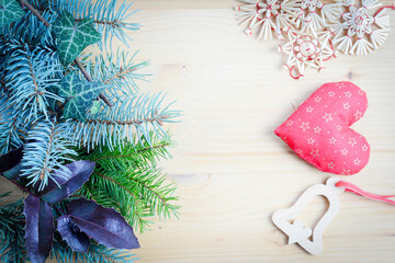 Christmas frame of spruce, natural christmas decorations on wooden background. Copy space. New Year lights. Flat lay.