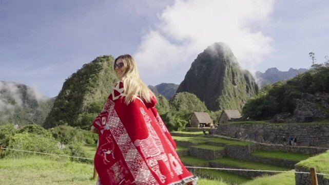 Happy tourist woman with peruvian poncho spinning in Machu Picchu. Joy of traveling. Wanderlust traveler Peru