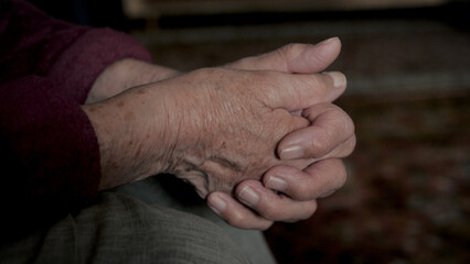 Close up of wrinkled hands, clasped fingers in lock of elderly old woman grandmother. Hands of...