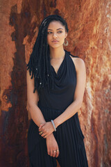 Fototapeta premium Serious, woman and fashion with braids outdoor for trendy clothes, cool jewellery or confidence of natural hair. Girl, relax and dreadlocks with creative outfit, unique accessories and culture style