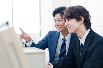 Fototapeta premium オフィスで議論をする2人の男性ビジネスマン