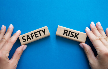 Safety or Risk symbol. Concept word Safety or Risk on wooden blocks. Businessman hand. Beautiful blue background. Business and Safety or Risk concept. Copy space