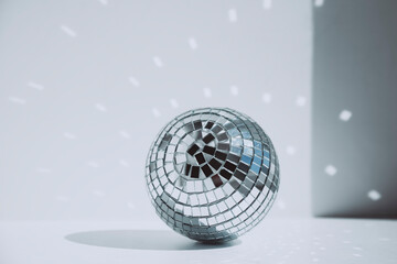 Shiny disco ball in front of wall at home in sunny day, copy space.