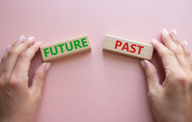 Future or Past symbol. Concept word Future or Past on wooden blocks. Businessman hand. Beautiful pink background. Business and Future or Past concept. Copy space