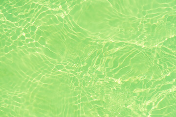 Abstract green background. Blue water with ripples on the surface. Defocus blurred transparent blue colored clear calm water surface texture with splashes and bubbles. Water waves with shining pattern