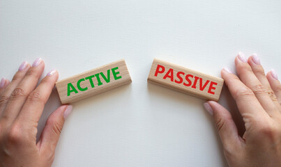 Active or Passive symbol. Concept word Active or Passive on wooden blocks. Businessman hand....