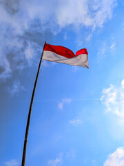 Indonesian flag with cloudy sky background
