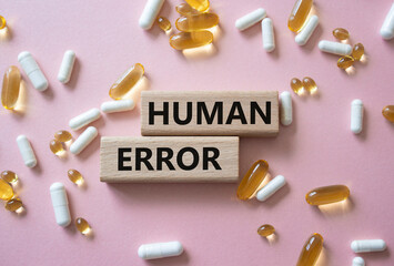 Human Error symbol. Concept word Human Error on wooden blocks. Beautiful pink background with...