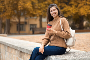 Casual portraif of caucasian pretty smiling young brunette woman 25-30 years old in brown knitted...