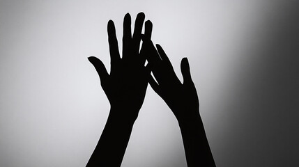 Clawed hands silhouette reaching up against a gray backdrop