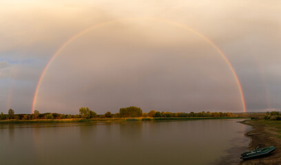 Landscape with a semicircular rainbow over the river