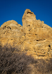 Sandstone rock formation reaching for clear blue sky