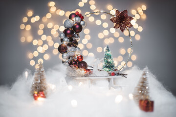 Christmas deoration concept on holidays with a porcelain derr, white fake snow for a festive december. In the background are bokeh balls made of lights