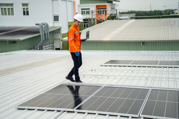 Builder mounting photovoltaic solar modules on roof of house. Back view of man engineer in helmet installing solar panel system outdoors. Concept of alternative and renewable energy.