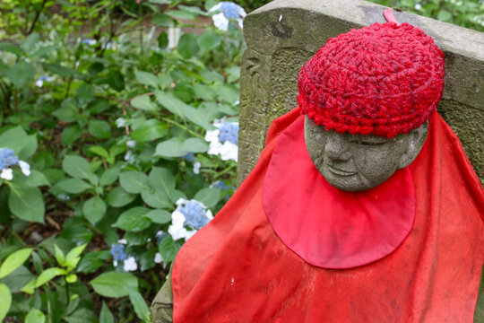 Stone Jizo statue resting in a tranquil green hydrangea garden