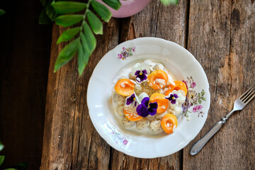 lazy dumplings with apricots, cream and edible flowers