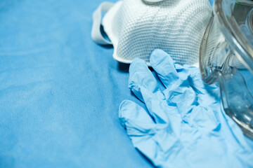 Gloves, face mask and glasses on blue background.Different medical protection tool.Personal protective equipment(PPE) for against infection disease.Medical accesory for infectious control