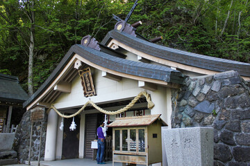 Togakushi Shrine building exterior with stone wall and donation box