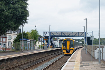 A local passenger train entering a deserted Starcross station on the Exe estuary in Devon UK