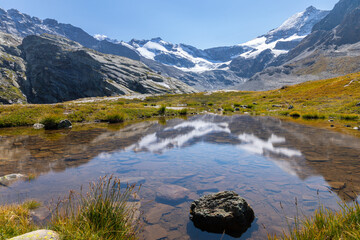 le reflet du Glacier des Évettes dans un petit lac dans les Alpes.