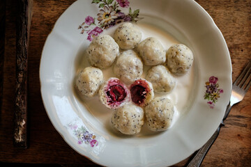 lazy dumplings with poppy seeds and cherry filling with cream sauce