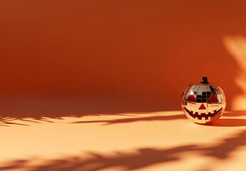 Pumpkin mirror ball in sunlight on the floor background with copy space