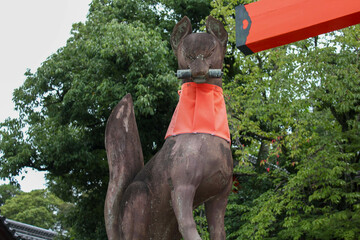Bronze fox statue holding scroll in mouth at Fushimi Inari Shrine