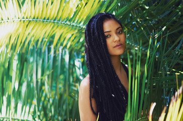 Woman, braids and portrait in nature for beauty, makeup and cosmetics with confidence at palm trees. Girl, style and relax in Bahamas with dreadlocks, aesthetic and freedom in summer for travel