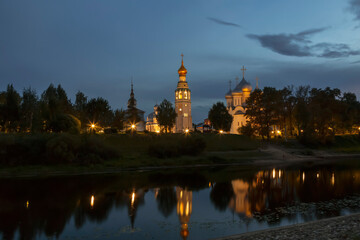 Obraz premium View of the Vologda Kremlin with the bell tower, St. Sophia Cathedral and the Church of Alexander Nevsky and their reflection in the Vologda River at night. Vologda, Russia