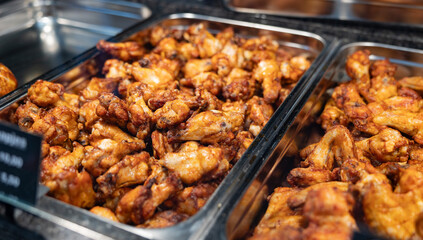 Freshly roasted chicken wings and legs on display. Read to eat, tasty and hot. Haagse Market in The Hague, Netherlands.