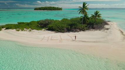 Woman stack on wild uninhabited island in sea. Help word written on sand, rescue concept. Young female in bikini waving hands ask to save her, like robinzon kruso. Summer vacation. Aerial drone flight