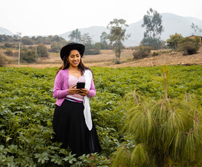 Atractiva joven campesina  con sombrero responde a videollamadas al aire libre, chica inteligente se comunica con entusiasmo en conferencia en línea al aire libre, emotiva caucásica señora hablando de