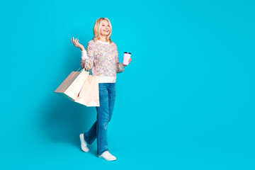Full body portrait of pretty aged lady walk empty space wear sweater isolated on turquoise color background