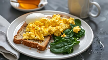 Scrambled eggs on toast with spinach and a boiled egg