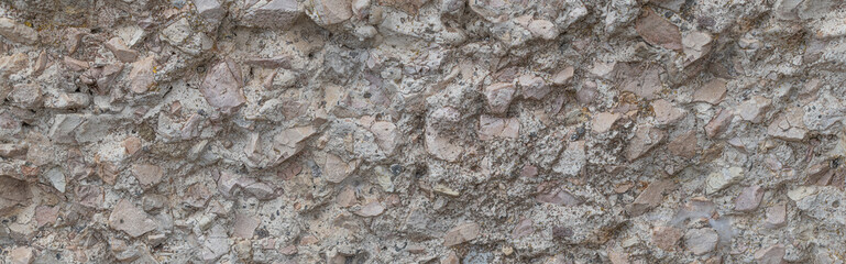 Rocky texture background with natural stones and fragments, featuring a surface in shades of pink, gray, and beige